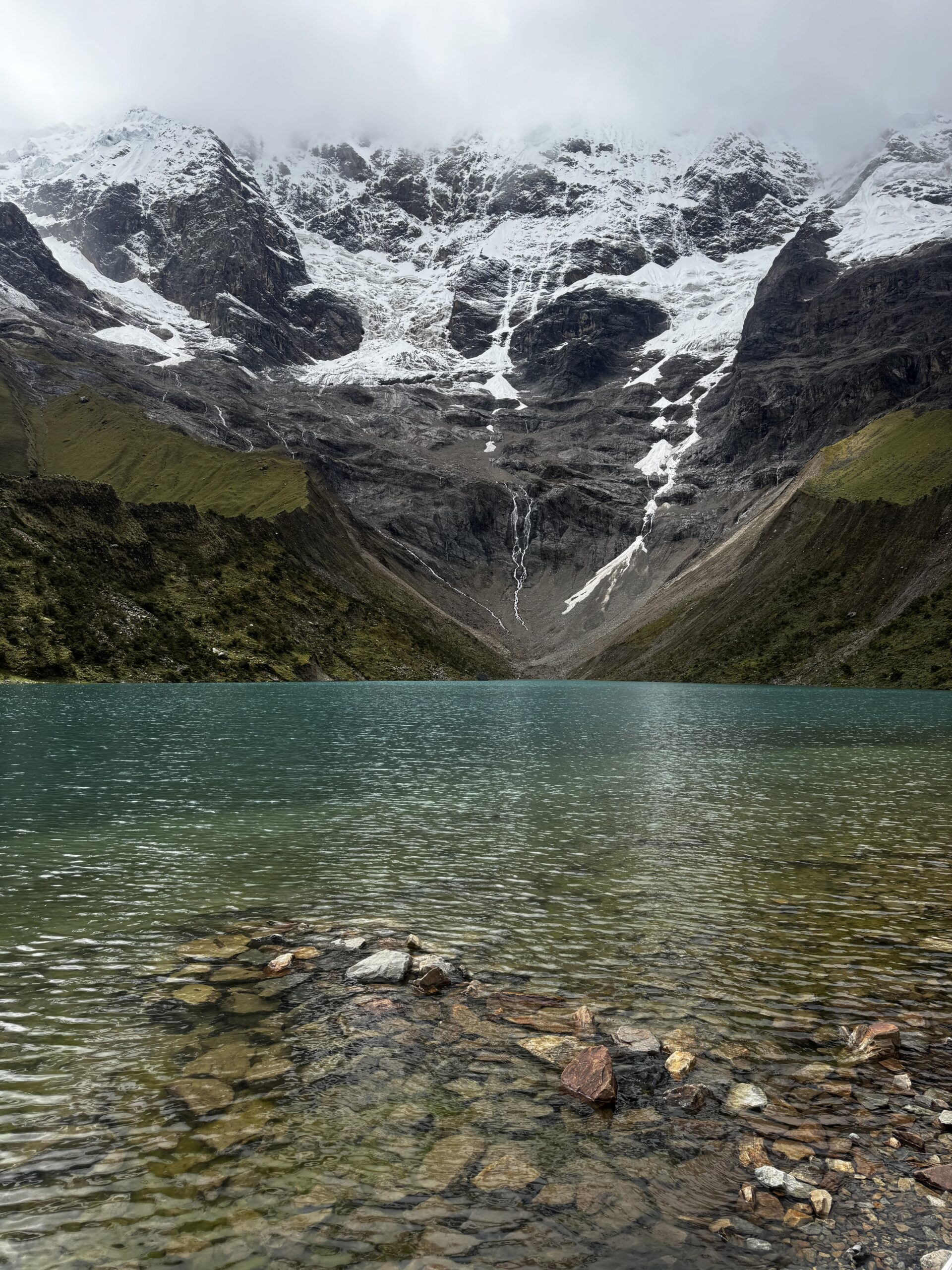A lake with a waterfall in the mountains.